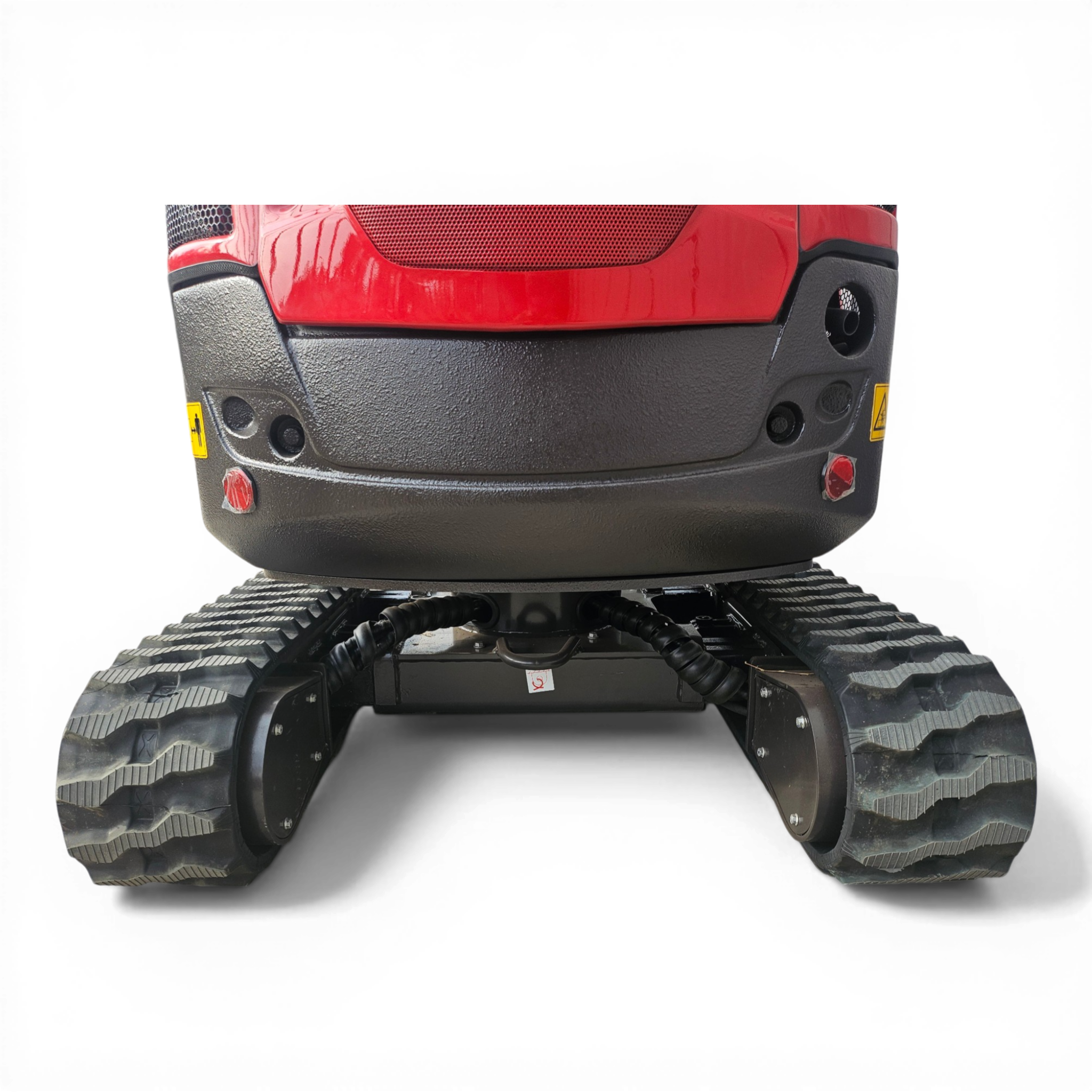 Close-up of the rear section of a red construction vehicle, showing large, knobby tires and a textured black bumper area.