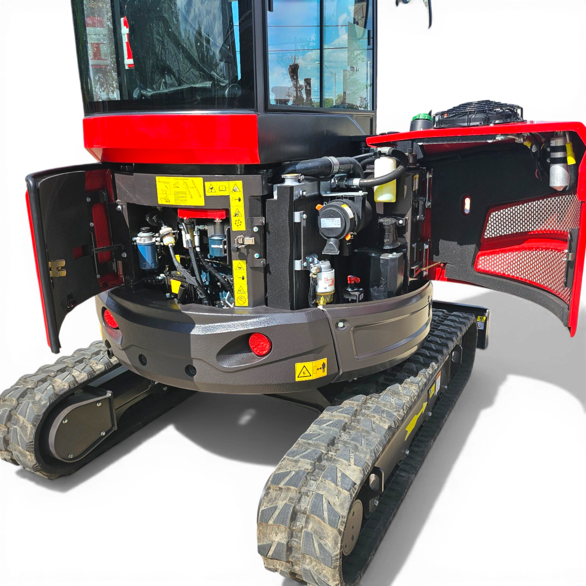 Front view of a red tracked construction vehicle with an open engine area and visible warning decals.