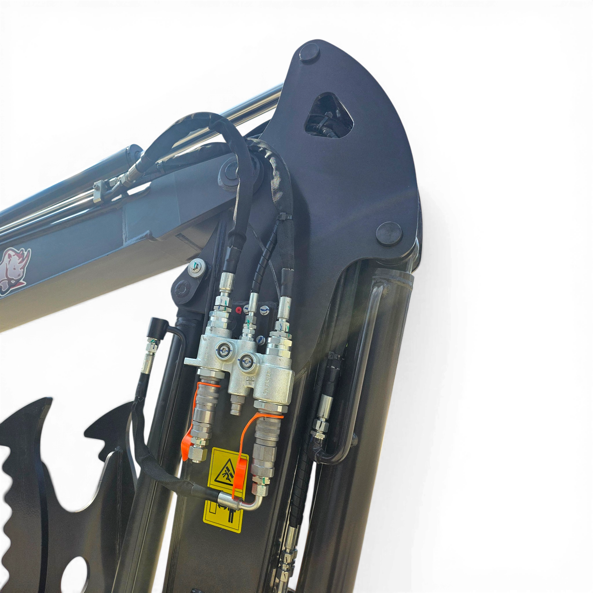 Close-up of hydraulic hoses and metal fittings on a heavy machinery arm with a yellow warning label nearby