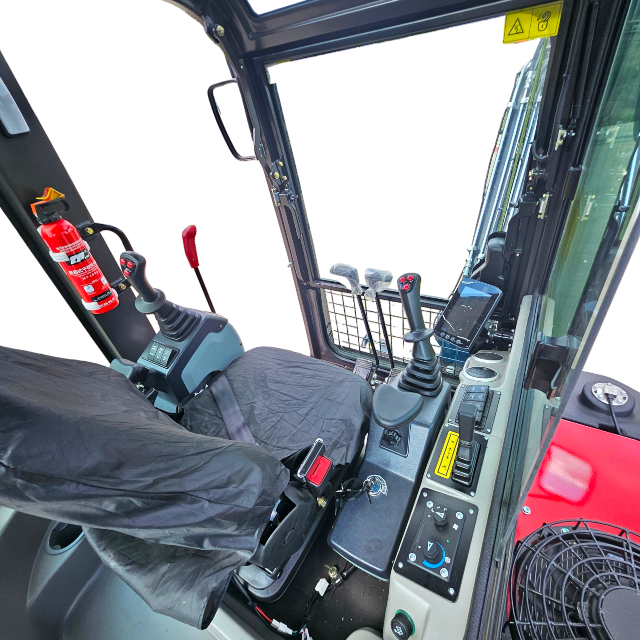 Inside a construction vehicle cab showing control levers, joystick, panel, and a red fire extinguisher nearby