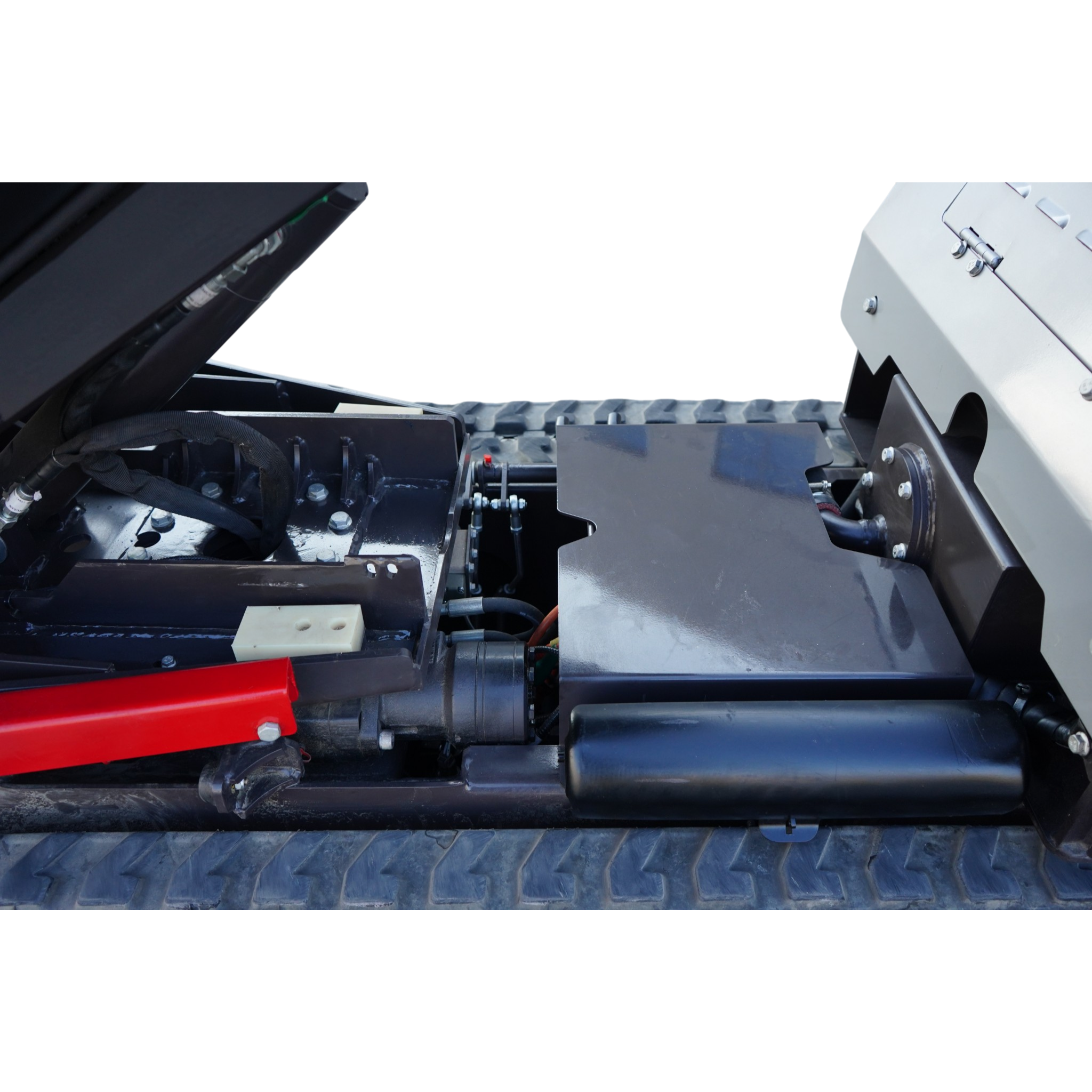Close-up view of industrial machinery internals showing metal frames, bolts, hoses, and a red structural beam on a textured floor.