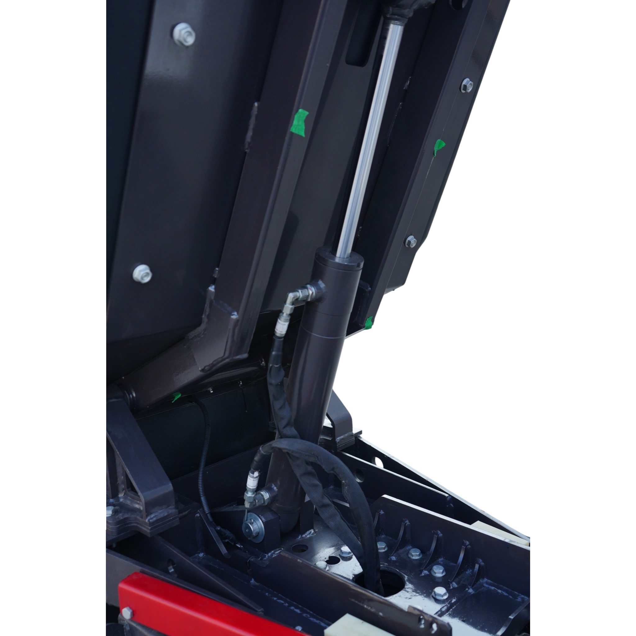 Close-up of a hydraulic cylinder and metal framework with bolts on a dark industrial machine.
