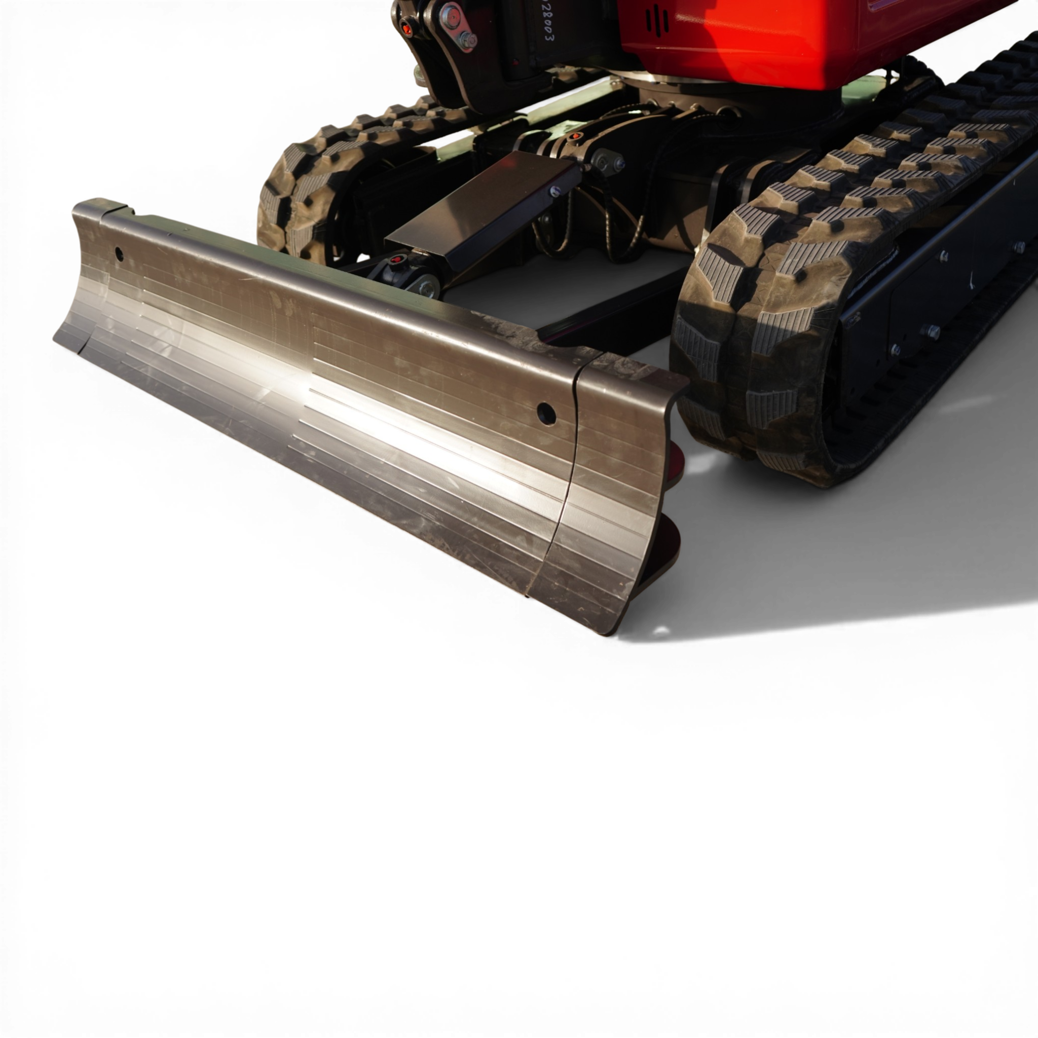 Close-up of a red tracked construction vehicle's blade and steel tracks.
