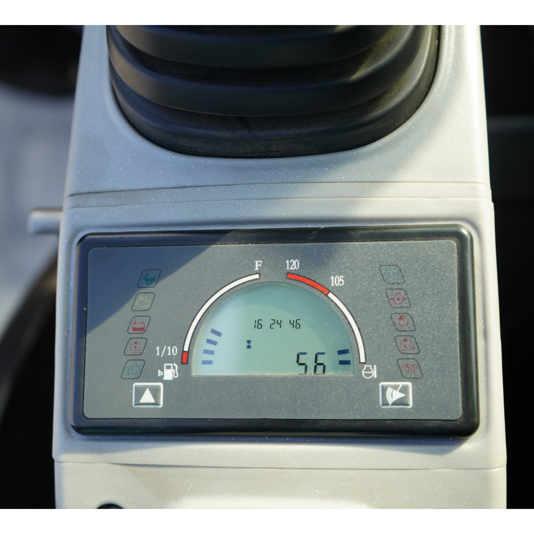Close-up of a vehicle's dashboard gauge: a large circular dial with Fahrenheit temperature marks (F) and warning icons around the edge, framed by the instrument panel.