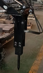 Heavy-duty forklift attachment with a pointed digging spike and chain on a vertical metal frame.