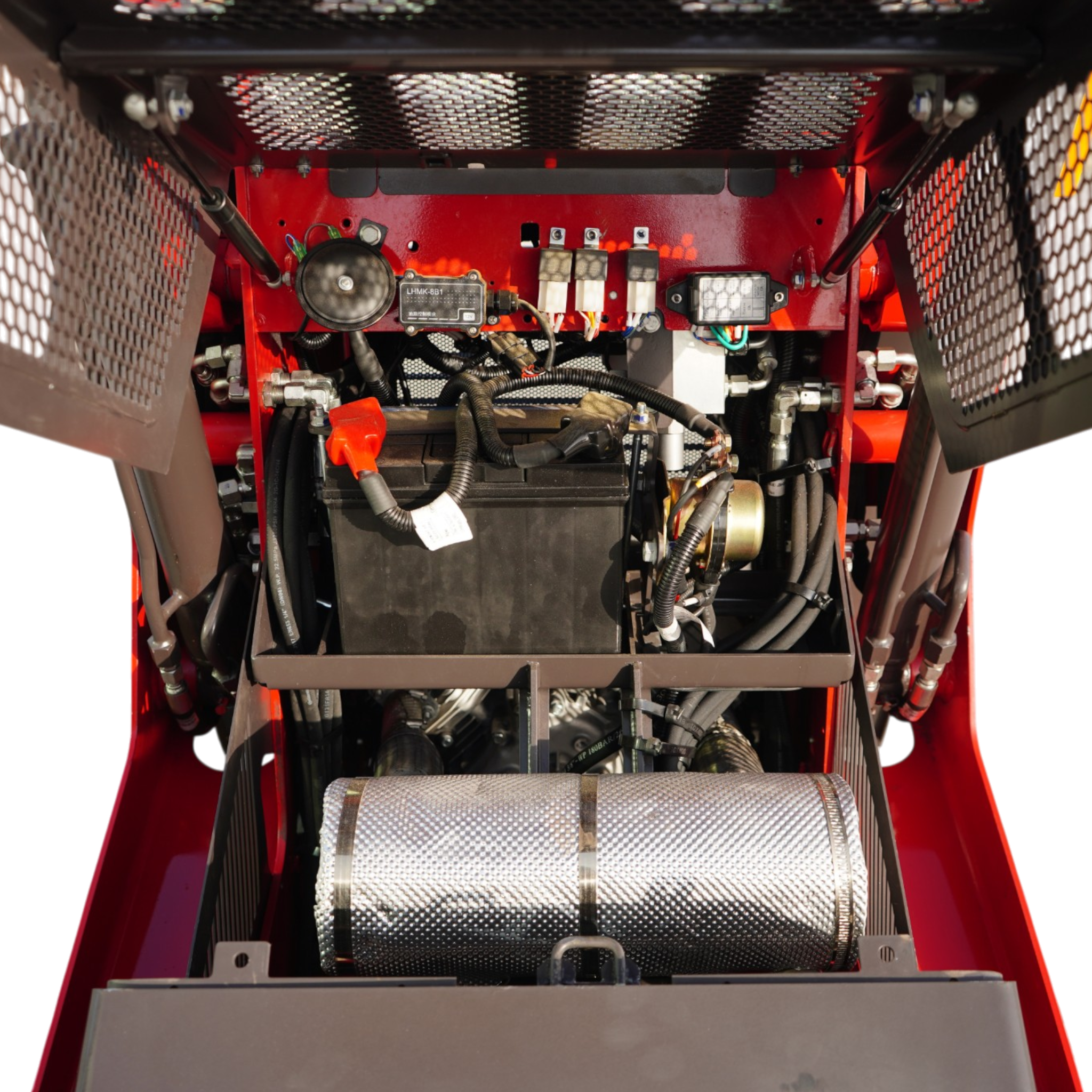 Interior view of a red industrial machine showing the battery, wiring harnesses, and electrical components amid metal framing and protective mesh guards.