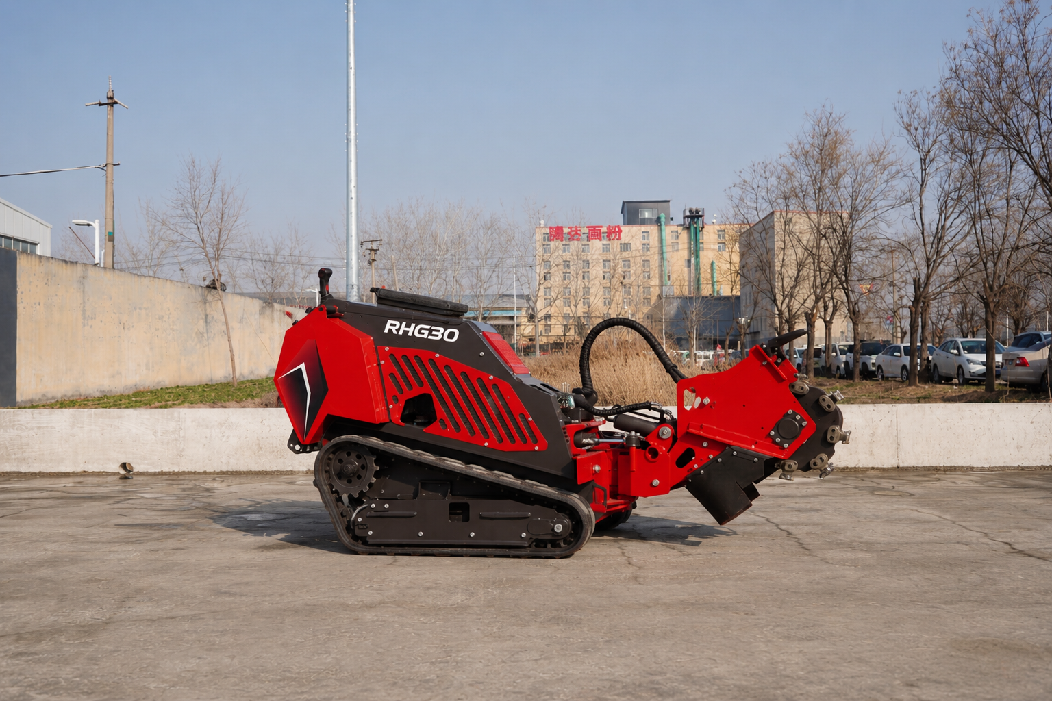 Red tracked stump grinder (RHG30) with a rotating cutting head, parked in a paved lot.