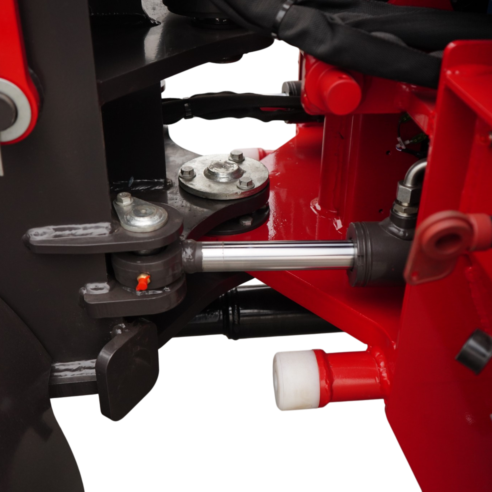 Close-up of red hydraulic machinery showing bolts, a black frame, and chrome piston rod in view.