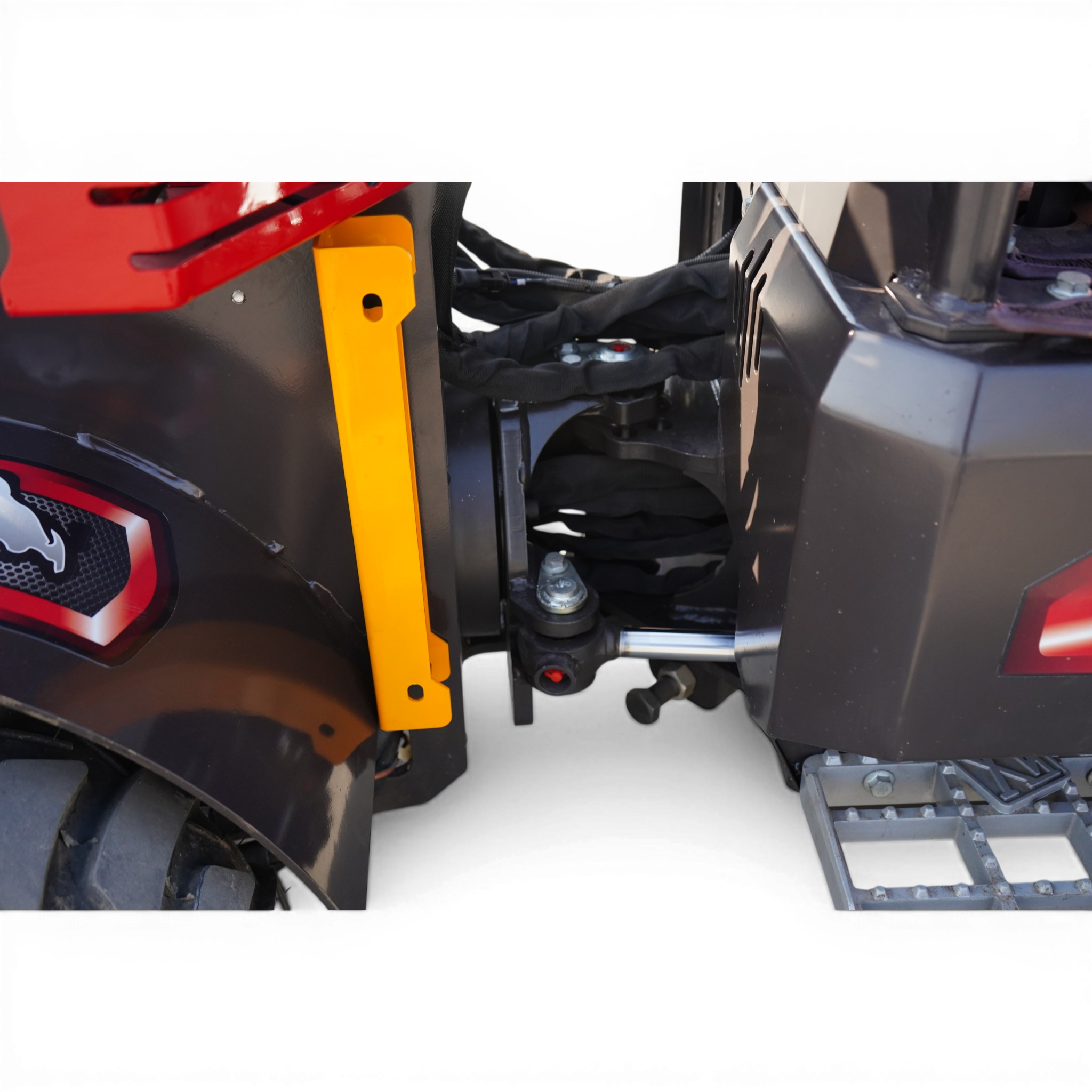 Close-up of a red motorcycle body panel with a bright yellow support bracket and exposed bolts.